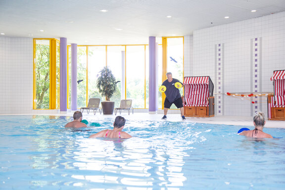 Schwimmbad_GLK In einem schönen und hellen Schwimmbad bewegen sich drei Rehabilitand*innen im Aqua-Fitness-Angebot.